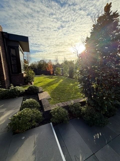 Front garden with stone edging, trimmed conifers and mowed lawn
